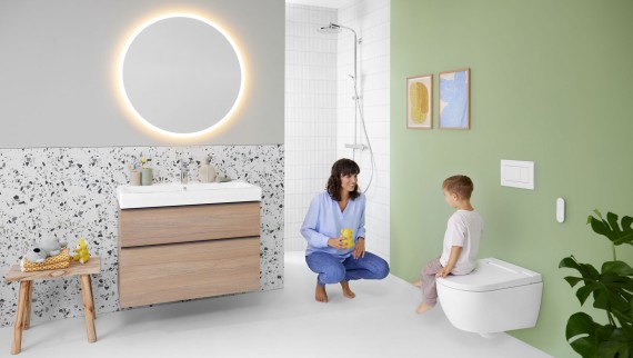 Woman and child in a colourful bathroom with Geberit Option mirror and Geberit AquaClean Alba