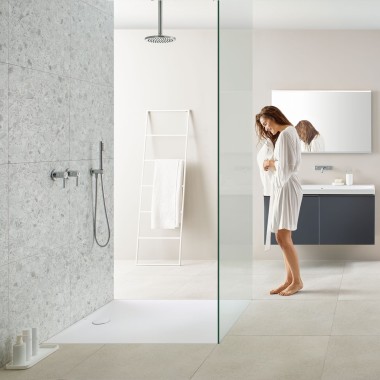 Woman in bathroom with walk-in shower and Geberit Olona shower tray